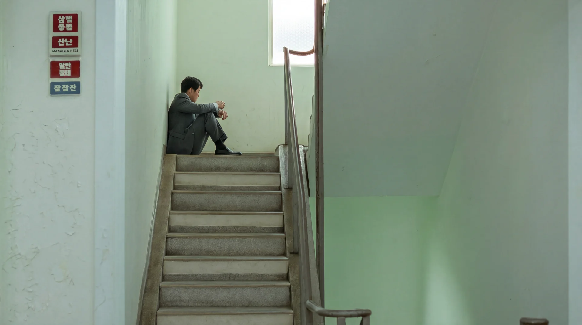 A person sitting alone on a stairwell landing
